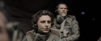 Movie still from “Dune” (2021), directed by Denis Villeneuve – A man and a woman wearing headphones in a helicopter; Close Up shot, Over the shoulder angle