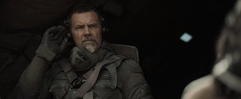 Movie still from “Dune” (2021), directed by Denis Villeneuve – An older man with a beard wearing headphones and a jacket; Close Up shot, Over the shoulder angle