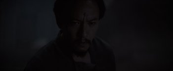 Movie still from “Dune” (2021), directed by Denis Villeneuve – A man with a cross on his forehead stares at the camera; Close Up shot, High angle