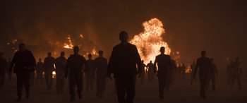 Movie still from “Dune” (2021), directed by Denis Villeneuve – A group of people walking in front of a fire; Wide shot, Low angle