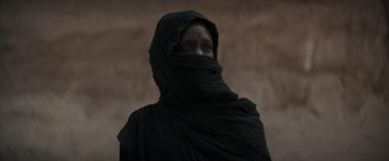 Movie still from “Dune” (2021), directed by Denis Villeneuve – A person with blue eyes is wearing a black veil; Close Up shot, Low angle