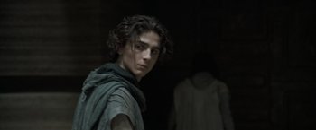 Movie still from “Dune” (2021), directed by Denis Villeneuve – A young man standing next to another man; Medium shot, Over the shoulder angle