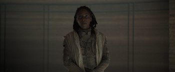 Movie still from “Dune” (2021), directed by Denis Villeneuve – A person in a space suit with blue eyes; Medium shot, Low angle