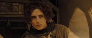 Movie still from “Dune” (2021), directed by Denis Villeneuve – A person with long dark hair; Close Up shot, Low angle