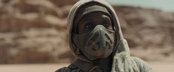 Movie still from “Dune” (2021), directed by Denis Villeneuve – A person wearing a mask and a hood; Close Up shot, Over the shoulder angle