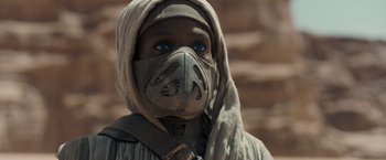Movie still from “Dune” (2021), directed by Denis Villeneuve – A person wearing a mask and a head covering; Close Up shot, Over the shoulder angle