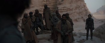 Movie still from “Dune” (2021), directed by Denis Villeneuve – A group of men standing next to each other; Wide shot, Over the shoulder angle
