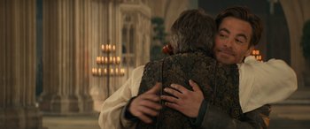 Movie still from “Dungeons & Dragons: Honor Among Thieves” (2023), directed by John Francis Daley – Two people hugging in a church with candles in the background; Medium shot, Over the shoulder angle