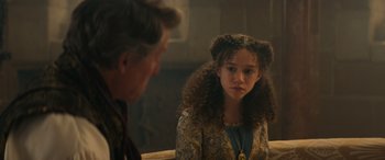 Movie still from “Dungeons & Dragons: Honor Among Thieves” (2023), directed by John Francis Daley – A young girl is sitting in front of an older man; Close Up shot, Over the shoulder angle