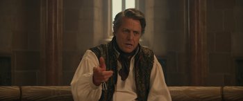 Movie still from “Dungeons & Dragons: Honor Among Thieves” (2023), directed by John Francis Daley – A man wearing a vest is talking to someone; Medium shot, Over the shoulder angle