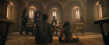 Movie still from “Dungeons & Dragons: Honor Among Thieves” (2023), directed by John Francis Daley – A group of people sitting in a room; Wide shot, Over the shoulder angle