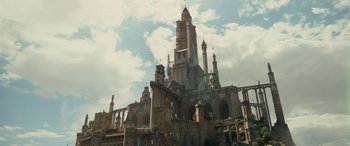 Movie still from “Dungeons & Dragons: Honor Among Thieves” (2023), directed by John Francis Daley – A large building with a clock tower on top of it; Extreme Wide shot, Low angle