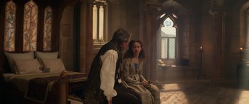 Movie still from “Dungeons & Dragons: Honor Among Thieves” (2023), directed by John Francis Daley – A man and a woman sitting on a bench in front of a stained glass window; Medium shot, Over the shoulder angle