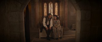 Movie still from “Dungeons & Dragons: Honor Among Thieves” (2023), directed by John Francis Daley – A man and a woman sitting on top of a white bench; Wide shot, High angle