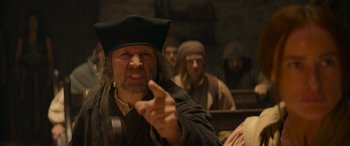 Movie still from “Dungeons & Dragons: Honor Among Thieves” (2023), directed by John Francis Daley – An old man in a black hat is pointing at the camera; Close Up shot, Low angle