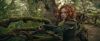 Movie still from “Dungeons & Dragons: Honor Among Thieves” (2023), directed by John Francis Daley – A red headed woman holding a sword in a wooded area; Medium shot, Low angle