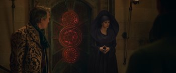 Movie still from “Dungeons & Dragons: Honor Among Thieves” (2023), directed by John Francis Daley – A woman dressed as a nun holding a book in front of a clock; Medium shot, High angle
