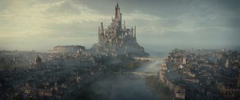 Movie still from “Dungeons & Dragons: Honor Among Thieves” (2023), directed by John Francis Daley – A castle like building sitting on top of a hill; Extreme Wide shot, High angle