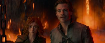 Movie still from “Dungeons & Dragons: Honor Among Thieves” (2023), directed by John Francis Daley – A man and a woman standing next to each other in front of fire; Medium shot, Over the shoulder angle