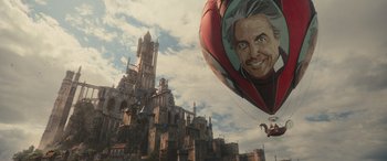 Movie still from “Dungeons & Dragons: Honor Among Thieves” (2023), directed by John Francis Daley – An old man balloon flying in front of an old castle; Extreme Wide shot, Low angle