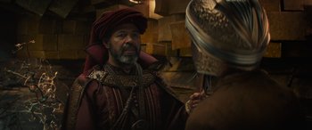 Movie still from “Dungeons & Dragons: Honor Among Thieves” (2023), directed by John Francis Daley – An old man in a turban and a beard is talking to a man in a turban; Medium shot, Over the shoulder angle