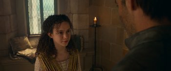 Movie still from “Dungeons & Dragons: Honor Among Thieves” (2023), directed by John Francis Daley – A young girl is looking at a man in front of a candle; Close Up shot, Over the shoulder angle
