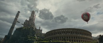 Movie still from “Dungeons & Dragons: Honor Among Thieves” (2023), directed by John Francis Daley – A cloudy sky over a building and a church; Extreme Wide shot, Low angle