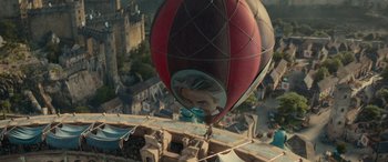 Movie still from “Dungeons & Dragons: Honor Among Thieves” (2023), directed by John Francis Daley – A hot - air balloon is flying over a city; Extreme Wide shot, Low angle