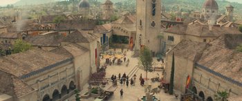 Movie still from “Dungeons & Dragons: Honor Among Thieves” (2023), directed by John Francis Daley – An aerial view of a medieval town with people walking around it; Extreme Wide shot, High angle