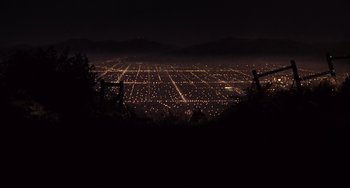 Movie still from “E.T. the Extra-Terrestrial” (1982), directed by Steven Spielberg – A view of a large city at night from a hill; Extreme Wide shot, High angle
