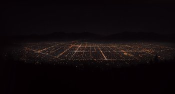 Movie still from “E.T. the Extra-Terrestrial” (1982), directed by Steven Spielberg – An aerial view of a large city at night; Extreme Wide shot, High angle
