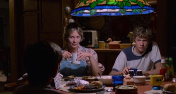 Movie still from “E.T. the Extra-Terrestrial” (1982), directed by Steven Spielberg – A group of people sitting at a table with food; Medium shot, Over the shoulder angle