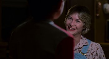 Movie still from “E.T. the Extra-Terrestrial” (1982), directed by Steven Spielberg – A woman smiling at a man in a suit; Close Up shot, Over the shoulder angle