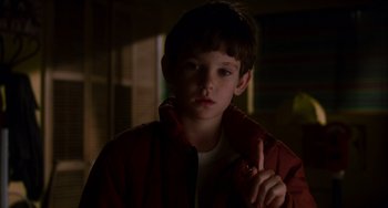 Movie still from “E.T. the Extra-Terrestrial” (1982), directed by Steven Spielberg – A boy in a red jacket is pointing to the camera; Close Up shot, Over the shoulder angle