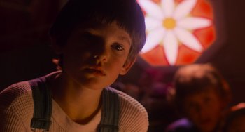 Movie still from “E.T. the Extra-Terrestrial” (1982), directed by Steven Spielberg – A young boy is looking into the camera; Close Up shot, Over the shoulder angle