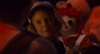 Movie still from “E.T. the Extra-Terrestrial” (1982), directed by Steven Spielberg – A little girl wearing a baseball cap and a hat; Close Up shot, Over the shoulder angle