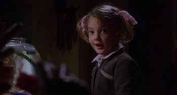 Movie still from “E.T. the Extra-Terrestrial” (1982), directed by Steven Spielberg – A little girl with pigtails is smiling for the camera; Close Up shot, Over the shoulder angle