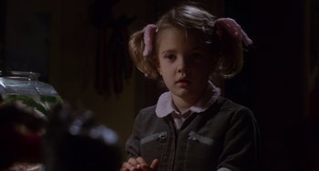 Movie still from “E.T. the Extra-Terrestrial” (1982), directed by Steven Spielberg – A little girl with pigtails is standing in a dark room; Close Up shot, Over the shoulder angle