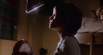 Movie still from “E.T. the Extra-Terrestrial” (1982), directed by Steven Spielberg – A young boy looking up at a light; Close Up shot, Low angle