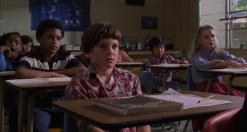 Movie still from “E.T. the Extra-Terrestrial” (1982), directed by Steven Spielberg – A group of children sitting at a desk in a classroom; Medium shot, Low angle