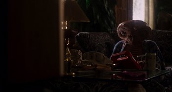 Movie still from “E.T. the Extra-Terrestrial” (1982), directed by Steven Spielberg – A table that has a lamp on top of it; Medium shot, High angle