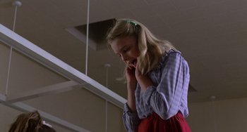 Movie still from “E.T. the Extra-Terrestrial” (1982), directed by Steven Spielberg – A woman in a blue and white striped shirt talking on a phone; Medium shot, Low angle