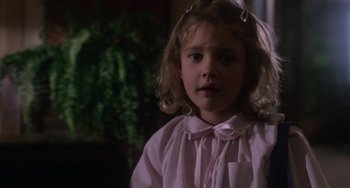 Movie still from “E.T. the Extra-Terrestrial” (1982), directed by Steven Spielberg – A little girl in a pink shirt is looking at the camera; Close Up shot, Over the shoulder angle