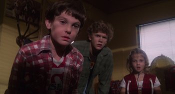 Movie still from “E.T. the Extra-Terrestrial” (1982), directed by Steven Spielberg – A group of young people standing next to each other in a room; Medium shot, Low angle