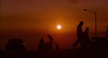 Movie still from “E.T. the Extra-Terrestrial” (1982), directed by Steven Spielberg – A group of people walking on a beach at sunset; Extreme Wide shot, Low angle
