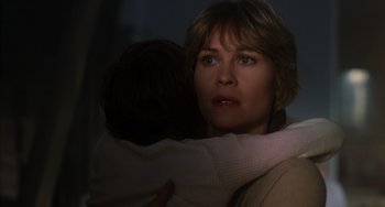 Movie still from “E.T. the Extra-Terrestrial” (1982), directed by Steven Spielberg – A person holding a child in a dark room; Close Up shot, Low angle
