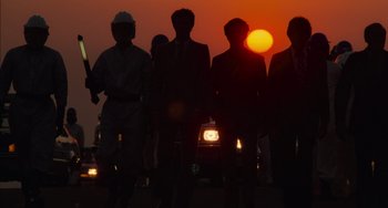 Movie still from “E.T. the Extra-Terrestrial” (1982), directed by Steven Spielberg – A group of people standing next to each other in front of a sunset; Wide shot, Low angle