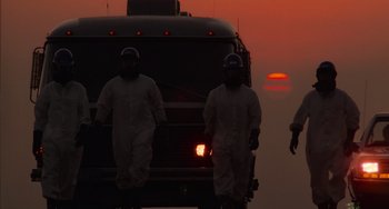 Movie still from “E.T. the Extra-Terrestrial” (1982), directed by Steven Spielberg – Two men in white coveralls are standing in front of a bus at sunset; Extreme Wide shot, Low angle