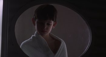 Movie still from “E.T. the Extra-Terrestrial” (1982), directed by Steven Spielberg – A boy in a white robe looking in a mirror; Close Up shot, High angle