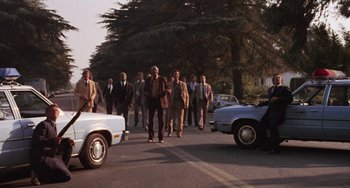 Movie still from “E.T. the Extra-Terrestrial” (1982), directed by Steven Spielberg – A group of men walking down a street; Wide shot, High angle